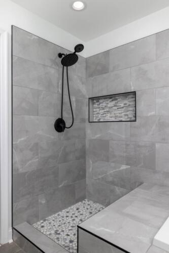 Caliber Home Builder, Hickory III, large master bathroom beautiful stone shower with a stone bench