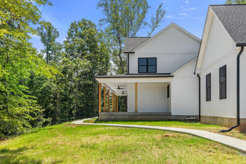 The Corbisiero - elegant farm style home - white exterior with black trim and oak porch posts, by Caliber Homebuilder