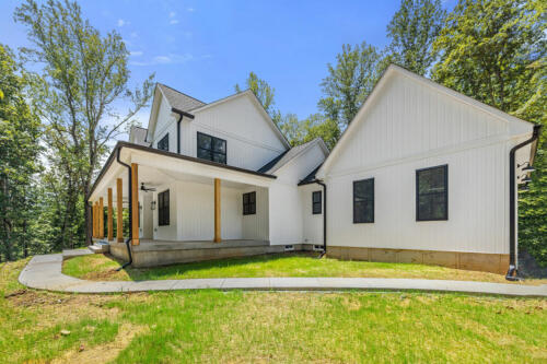 The Corbisiero - elegant farm style home - white exterior with black trim and oak porch posts, by Caliber Homebuilder