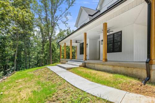 The Corbisiero - elegant farm style home - white exterior with oak porch posts, by Caliber Homebuilder
