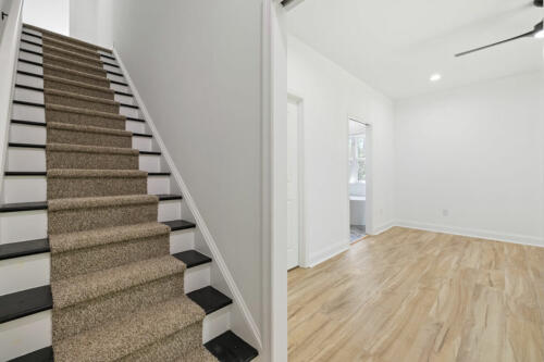 The Corbisiero - stairway with black treads and camel-colored carpet runner, by Caliber Homebuilder