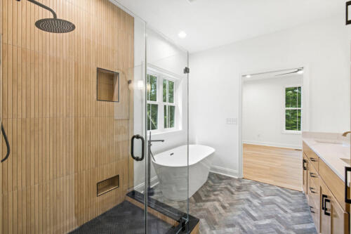 The Corbisiero - elegant full bathroom with walk-in shower and porcelain tub, by Caliber Homebuilder