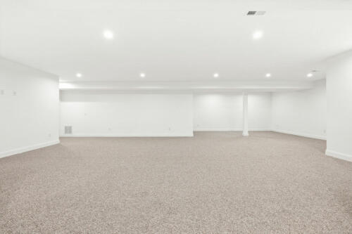 The Corbisiero - large finished basement with carpet floor, by Caliber Homebuilder