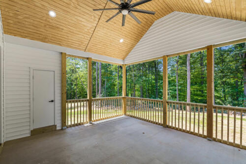 The Corbisiero - back patio with deck-style railing, vaulted ceiling, and ceiling fan, by Caliber Homebuilder
