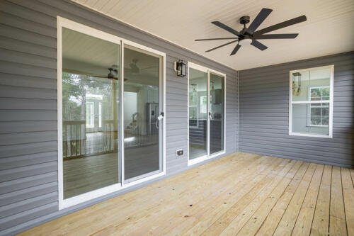 Caliber Home Builder, The Hart, covered deck with a fan and multiple glass sliding doors